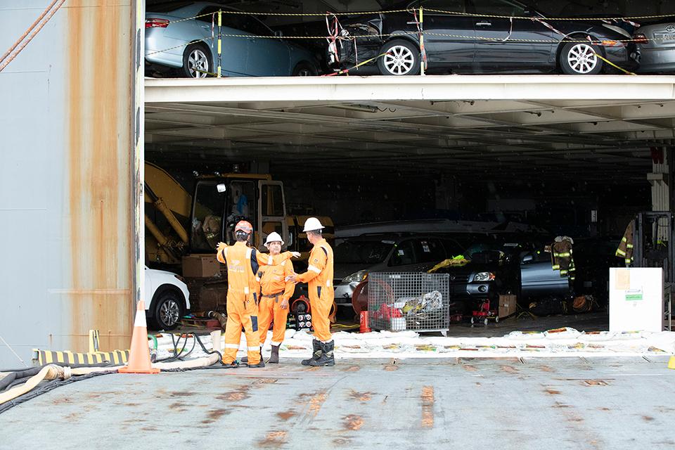 Response team assessing damaged vehicles inside the car carrier's cargo deck